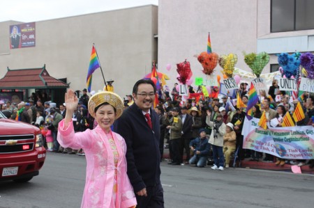 Garden Grove Councilwoman Dina Nguyen, accompanied  by her husband Joseph Dovinh, waves to the crowds at 2013 Tet Parade in Westminster